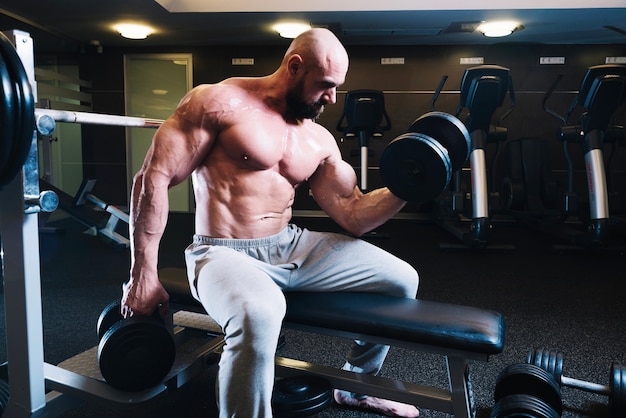 Muscular man lifting dumbbells