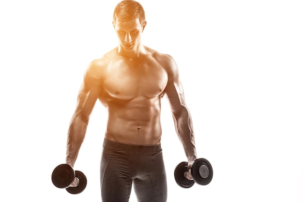 Free photo muscular man showing perfect body with dumbbells and looking at the camera, isolated on white background. whith solar flare