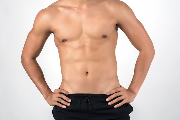 Free photo muscular man showing six pack abs isolated on white background.