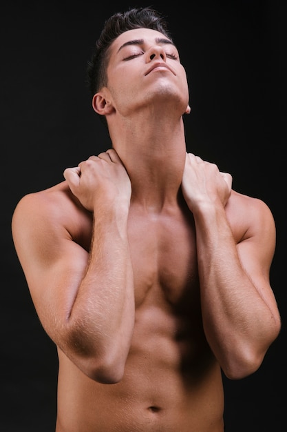 Мускулистый мужчина растягивает шею