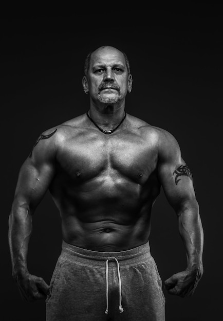 Free photo muscular middle age man posing in studio. isolated on grey