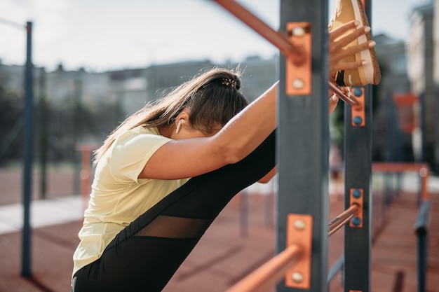 Foto gratuita donna muscolare che fa ginnasta flessibile all'aperto