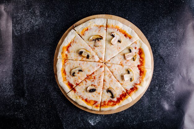 Mushroom, cheese, tomato sauce pizza cut into slices.