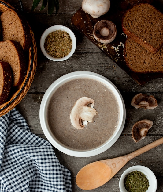 Mushroom cream soup with cream in a white bowl and basket