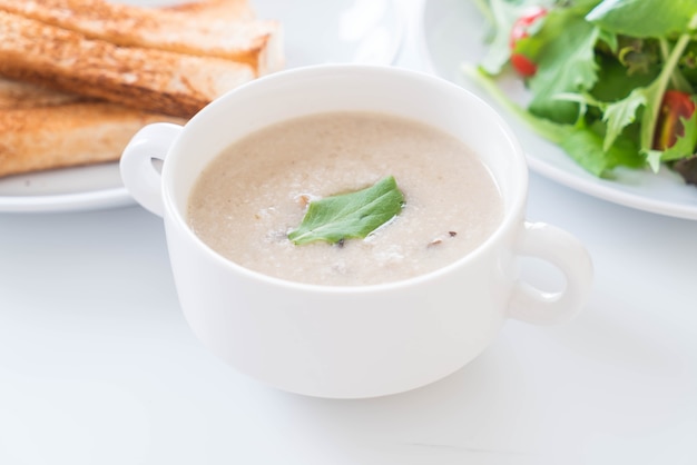mushroom soup and bread in white ceramic cup