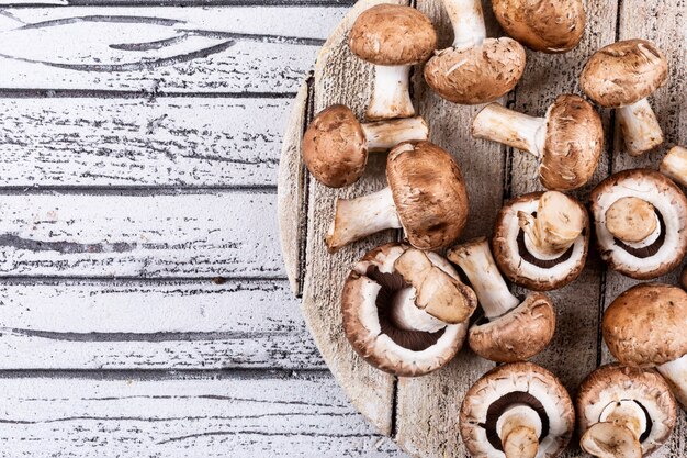 Mushrooms on cutting board on a light wooden table