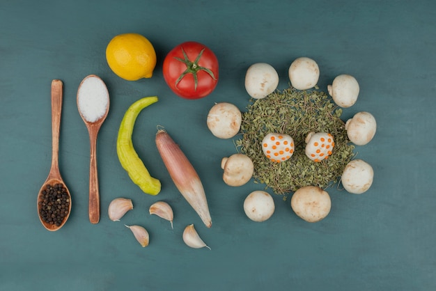 Mushrooms, lemon, pepper, mint, tomato and spices on blue table.