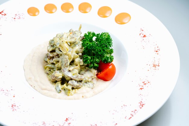 Mushrooms in sour cream with herbs and tomato