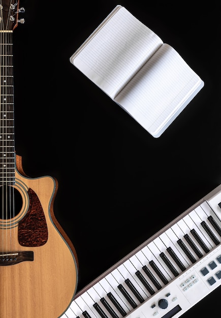 黒のアコースティックギターのメモ帳と音楽キーと音楽の背景