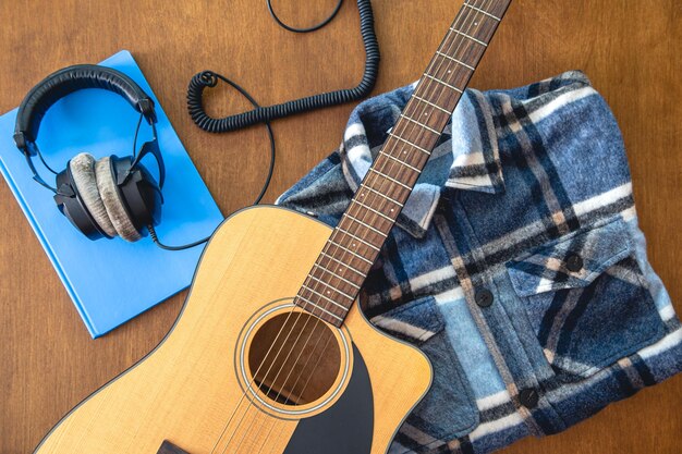 Music background with guitar headphones and notepad top view