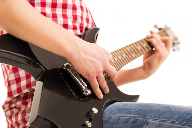 Music, close-up. Young musician holding electro guitar