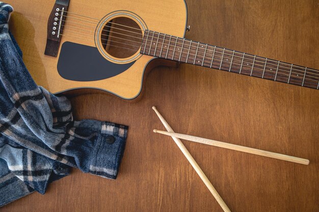 Free photo music composition with acoustic guitar and drumsticks top view