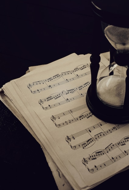 Music notes on papers and hourglass