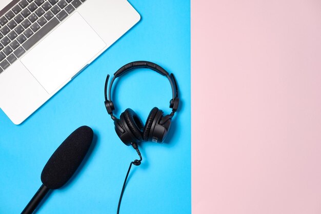 Музыка или фон подкаста с наушниками, микрофоном, кофе и ноутбуком на розовом столе, плоская планировка