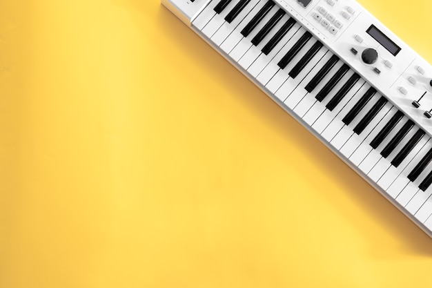 Musical background with musical keys on yellow flat lay copy space