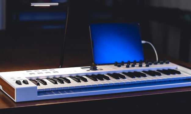 Free photo musical keyboard and tablet in a dark room music production