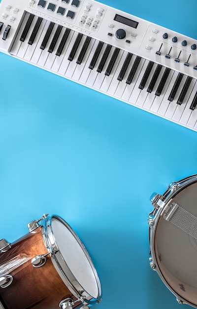 Музыкальные клавиши и барабаны на синем фоне, плоская планировка, концепция музыкального творчества.