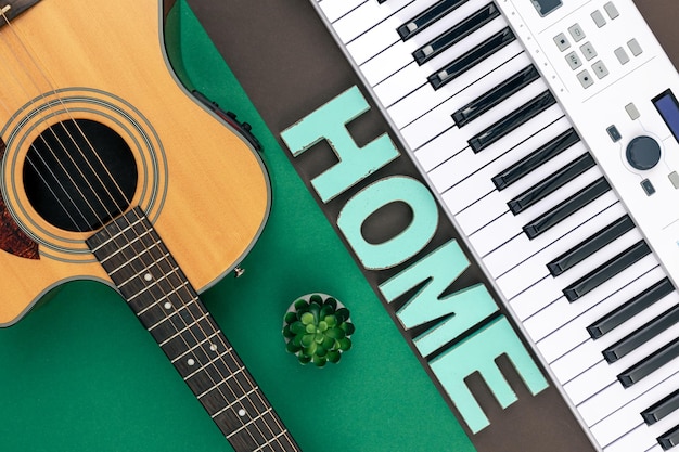 Foto gratuita tasti musicali chitarra e parola decorativa casa su uno sfondo colorato