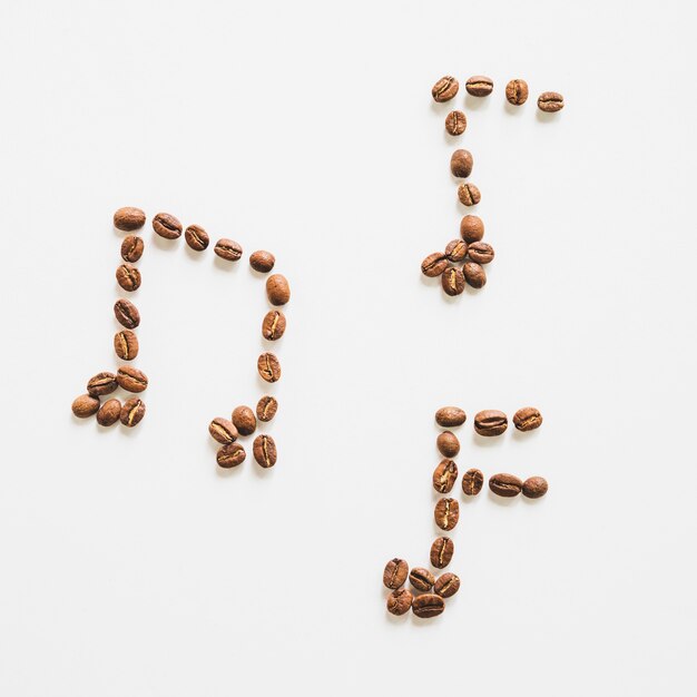 Musical notes made with roasted coffee beans on white background