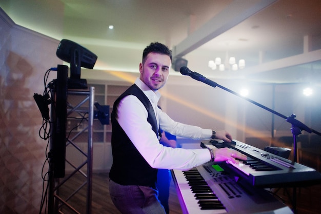Free photo musicial music live band performing on a stage with different lights keyboardist play