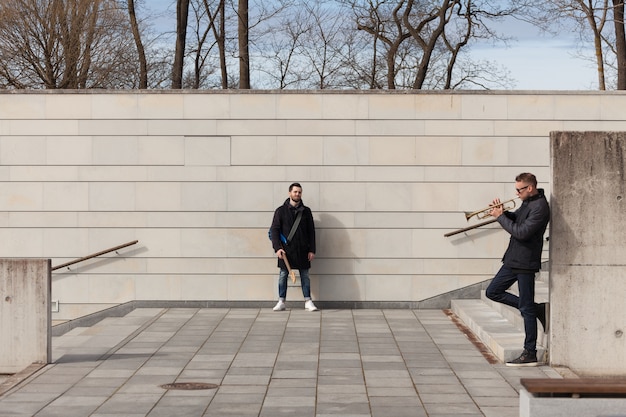 Foto gratuita amici del musicista nell'ambiente urbano