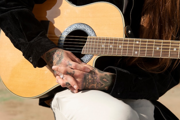 Foto gratuita musicista che tiene la chitarra nelle strade