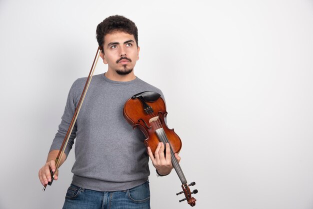 Musician holding his violin and thinking about the next piece to play.