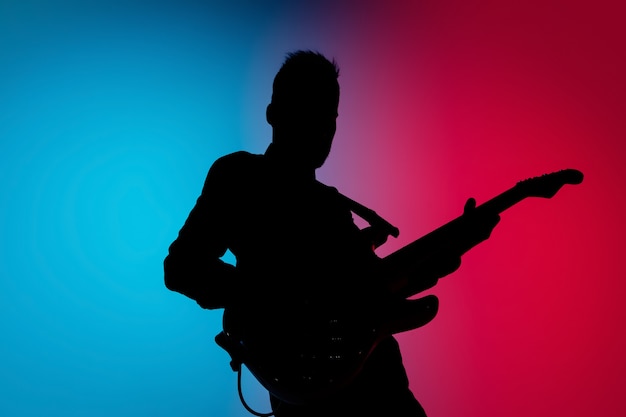 Musician isolated on dark studio in neon light