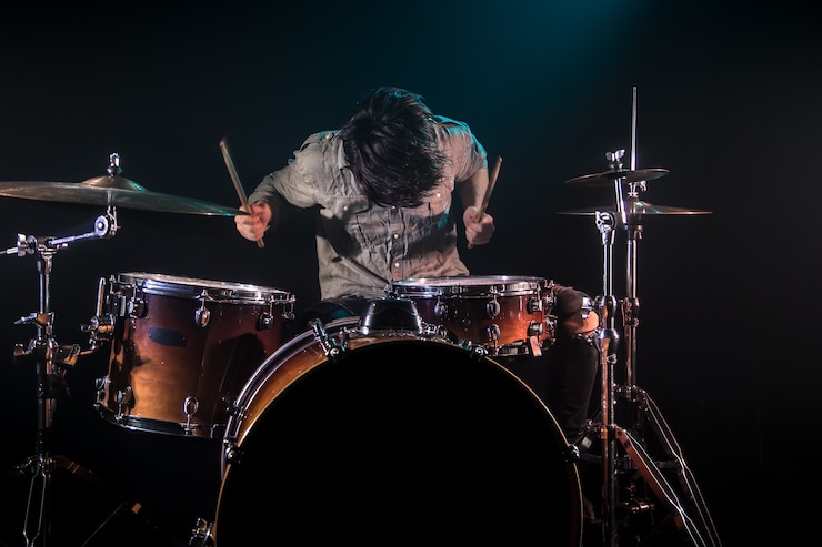 無料Photo ドラム、黒の背景と美しい柔らかな光、感情的な演奏、音楽のコンセプトを演奏するミュージシャン
