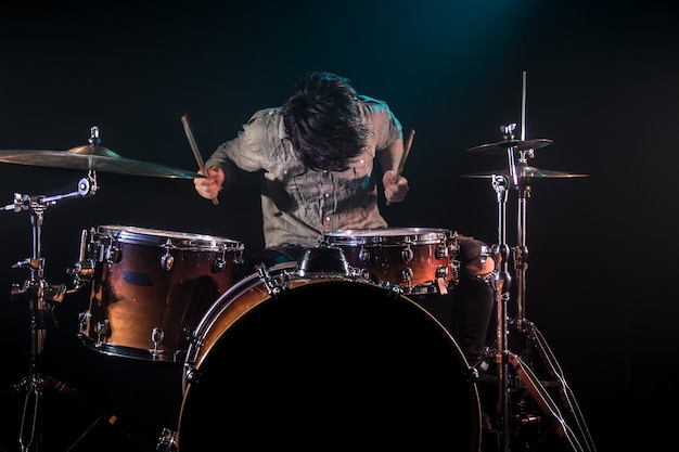 musician playing drums, black background and beautiful soft light, emotional play, music concept