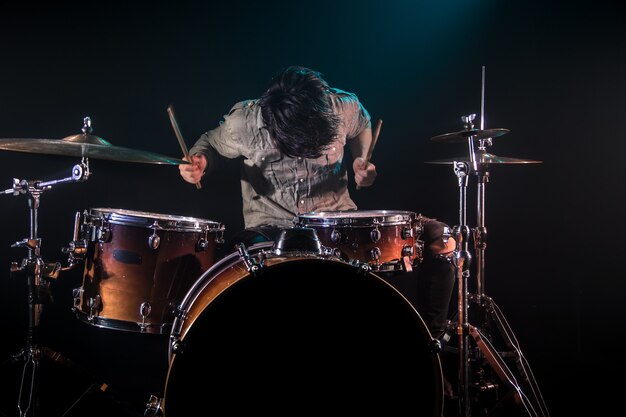 musician playing drums, black background and beautiful soft light, emotional play, music concept