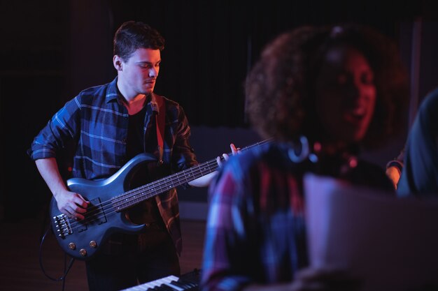 Musician playing electronic guitar in studio