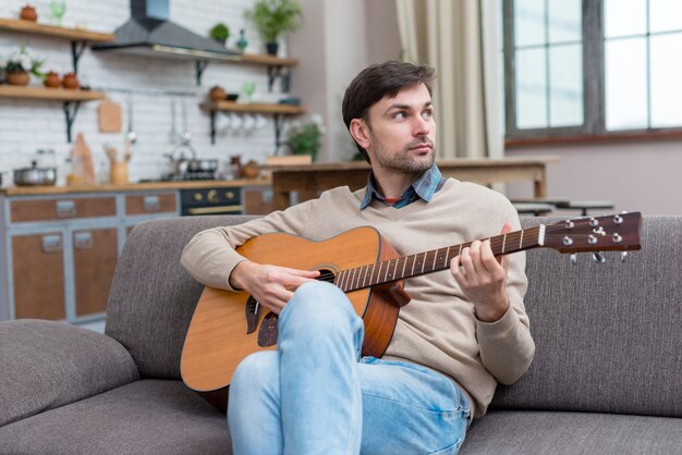 Musician playing the guitar indoors