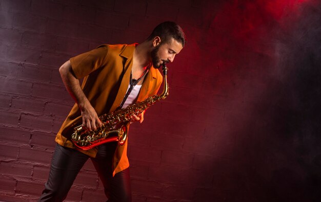 Musician playing the saxophone in fog with copy space