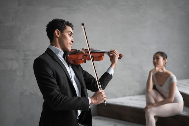 Musician playing violin for ballerina