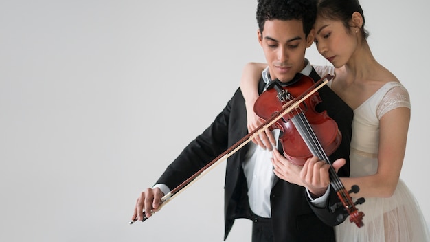 Musician playing violin with ballerina and copy space