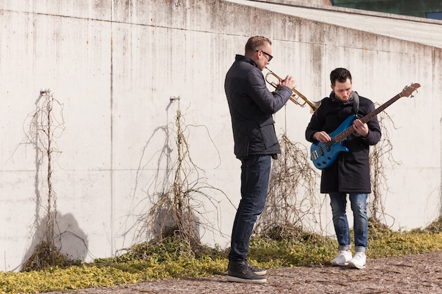 Musicians playing in front of a wall