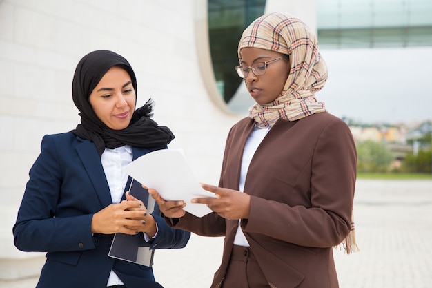 契約テキストを議論するイスラム教徒のビジネス女性