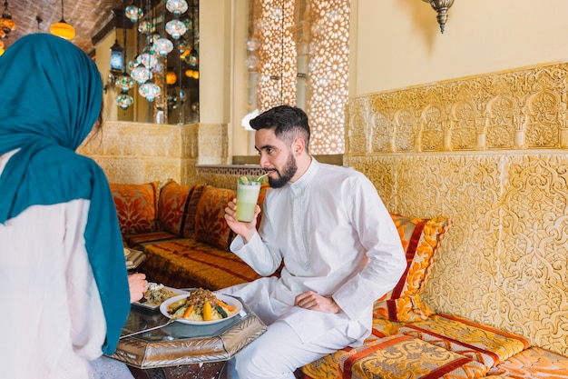 レストランに座っているイスラム教徒のカップル