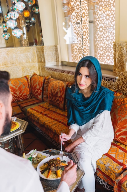 Мусульманская пара разговаривает в ресторане арабского