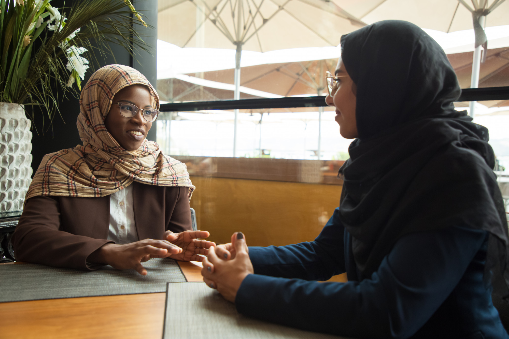 Muslim female colleagues chatting during lunch break