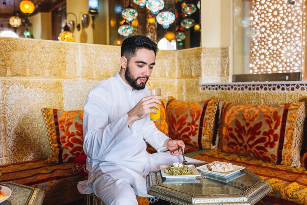 Muslim man eating in restaurant