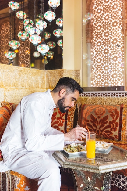 Muslim man eating in restaurant