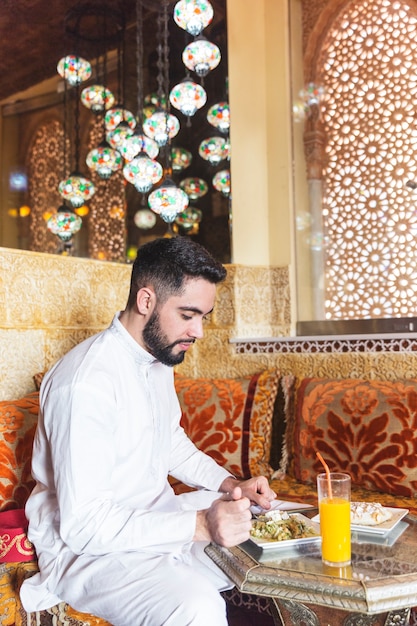 Free photo muslim man eating in restaurant