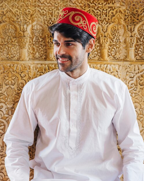 Muslim man in front of golden wall