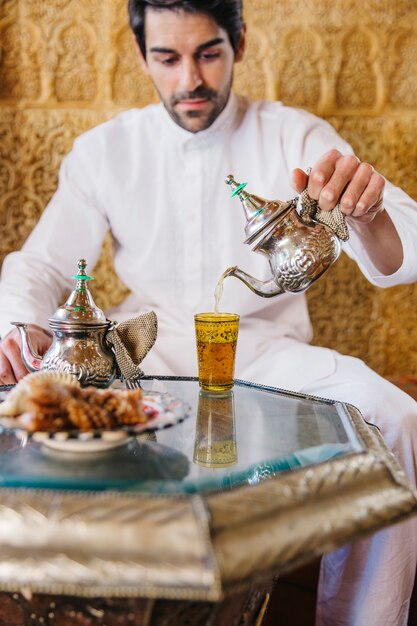 イスラム教徒の男が紅茶を注ぐ