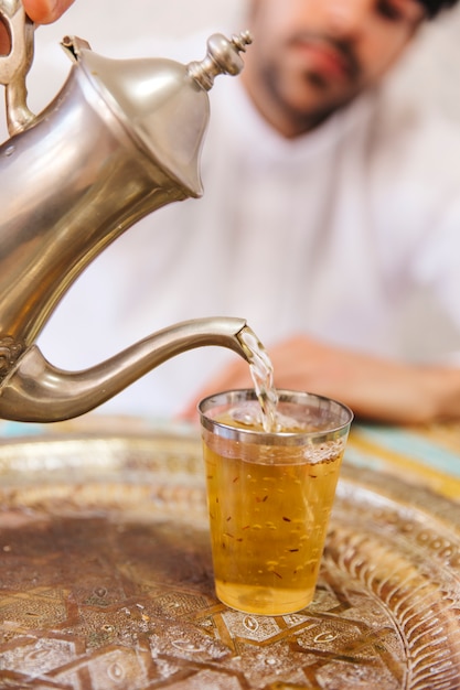 Free photo muslim man sitting on table with tea