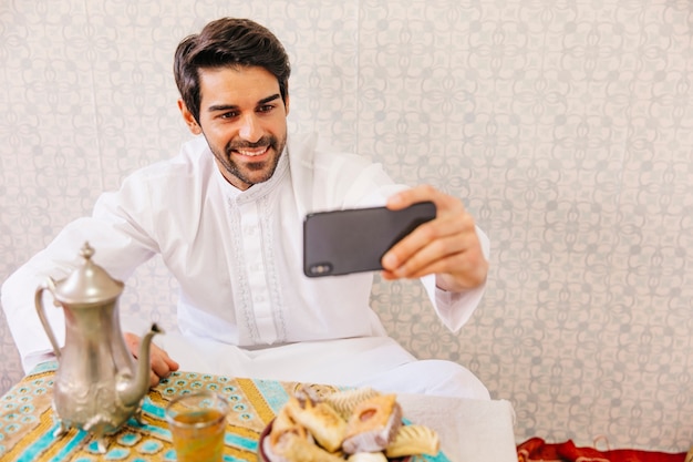 Foto gratuita uomo musulmano prendendo selfie