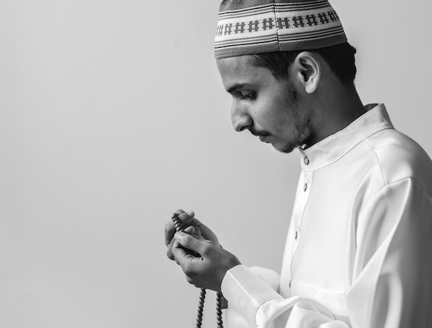 tasbihで数えることを追跡するためにmisbahaを使用しているイスラム教徒の男