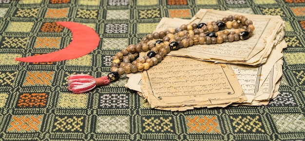 코란의 고대 페이지가 있는 이슬람 기도 구슬. 이슬람과 이슬람 개념. 아랍어 책의 고대 오래된 종이